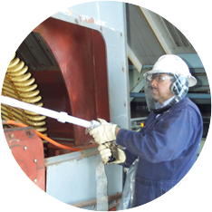 a man wearing a hard hat and goggles performing CO2 blasting