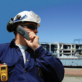 a man wearing a hard hat is talking on a cell phone